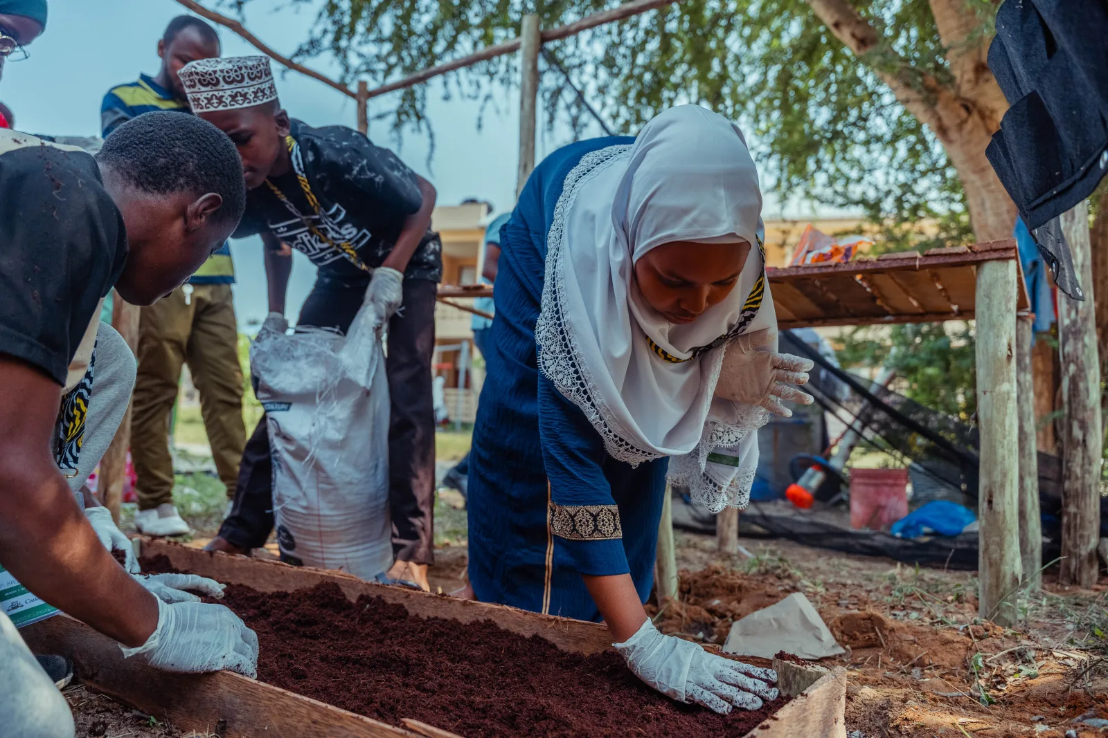Youth bootcamp participants working together on an outdoor soil activity